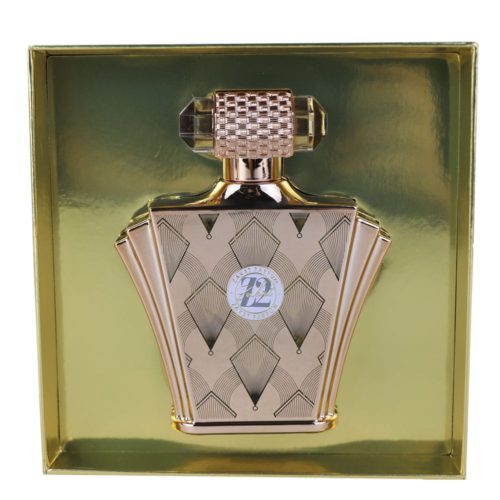 A close-up of the Z12 perfume bottle in pastel pink, decorated with a silver emblem and an embossed floral pattern, tied with a silver ribbon.